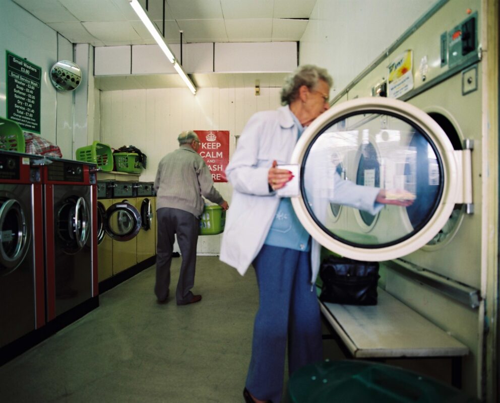 Woman loading up dryer in a launderette